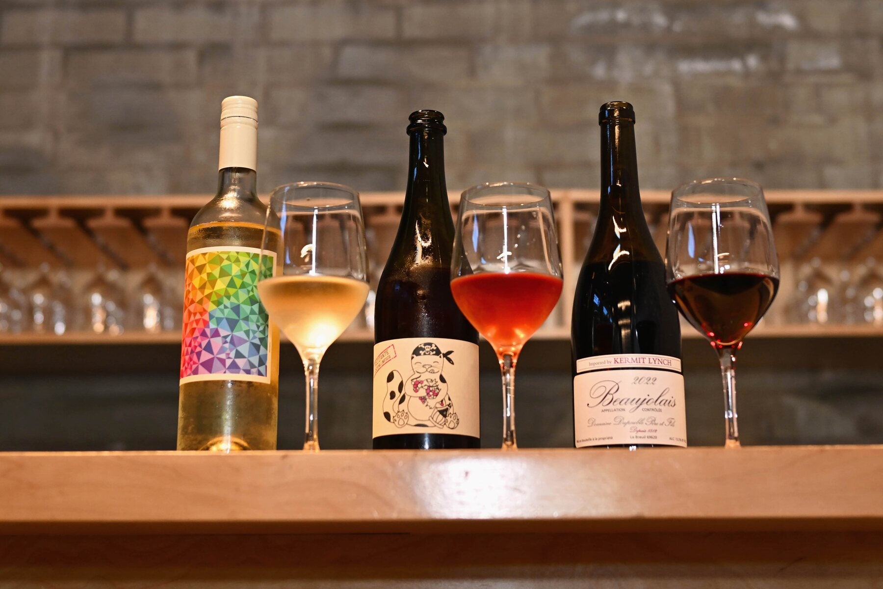 A bottle being poured into a wine glass at the bar